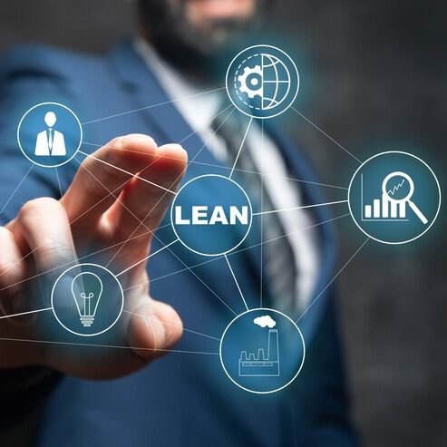 Método lean en inversión inmobiliaria Hombre de negocios señalando gráficos y términos sobre mejora continua y eficiencia.