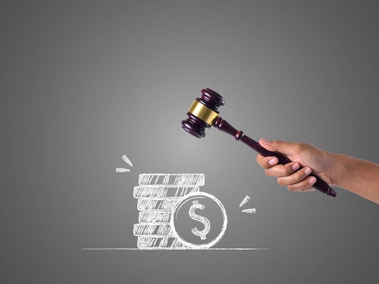 Subasta judicial Bajo fondo gris, un mazo de juez y monedas apiladas con un signo de dólar.