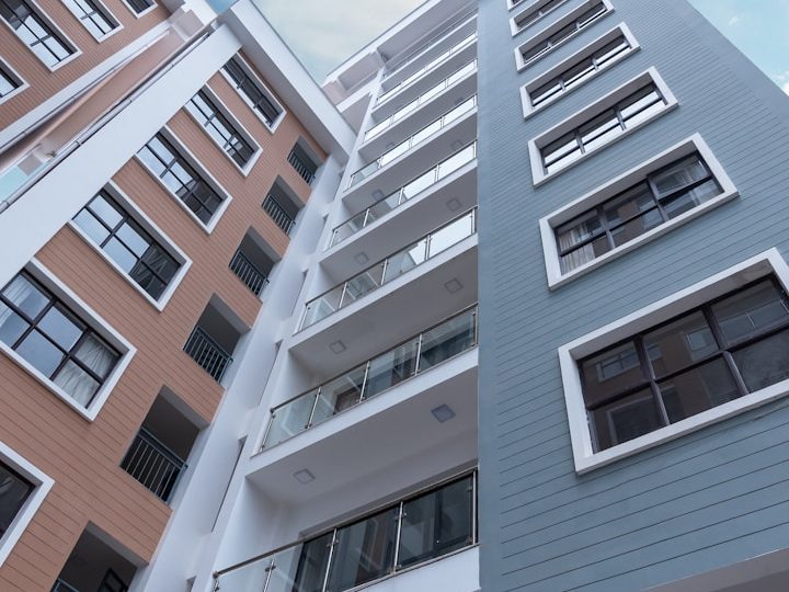 Vivienda mercado libre Edificio moderno con varios pisos y balcones, en tonos gris y naranja.